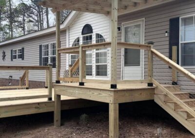 Custom wooden covered porch and attached deck built by Bystone in Birmingham, AL