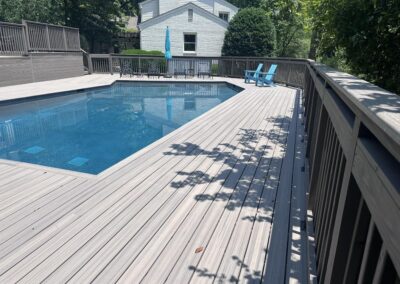 Custom wooden pool deck surround with safety railings built by Bystone around an in-ground swimming pool in Vestavia Hills, AL.