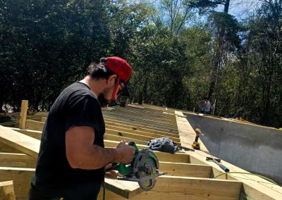 Bystone carpenter using a circular saw to cut wood framing during a custom deck construction project in Birmingham, AL.