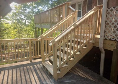 Custom wood deck staircase with a decorative lattice style railing built by Bystone in Birmingham, AL.
