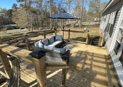 Spacious backyard wooden deck addition built by Bystone in Birmingham, AL, featuring a protective wood railing system.