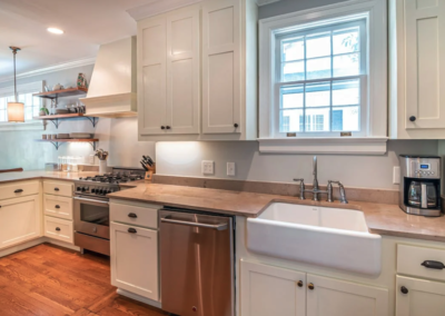 Farmhouse kitchen remodel by Bystone in Birmingham, AL, featuring a white apron front sink, butcher block countertops, and beige cabinets.