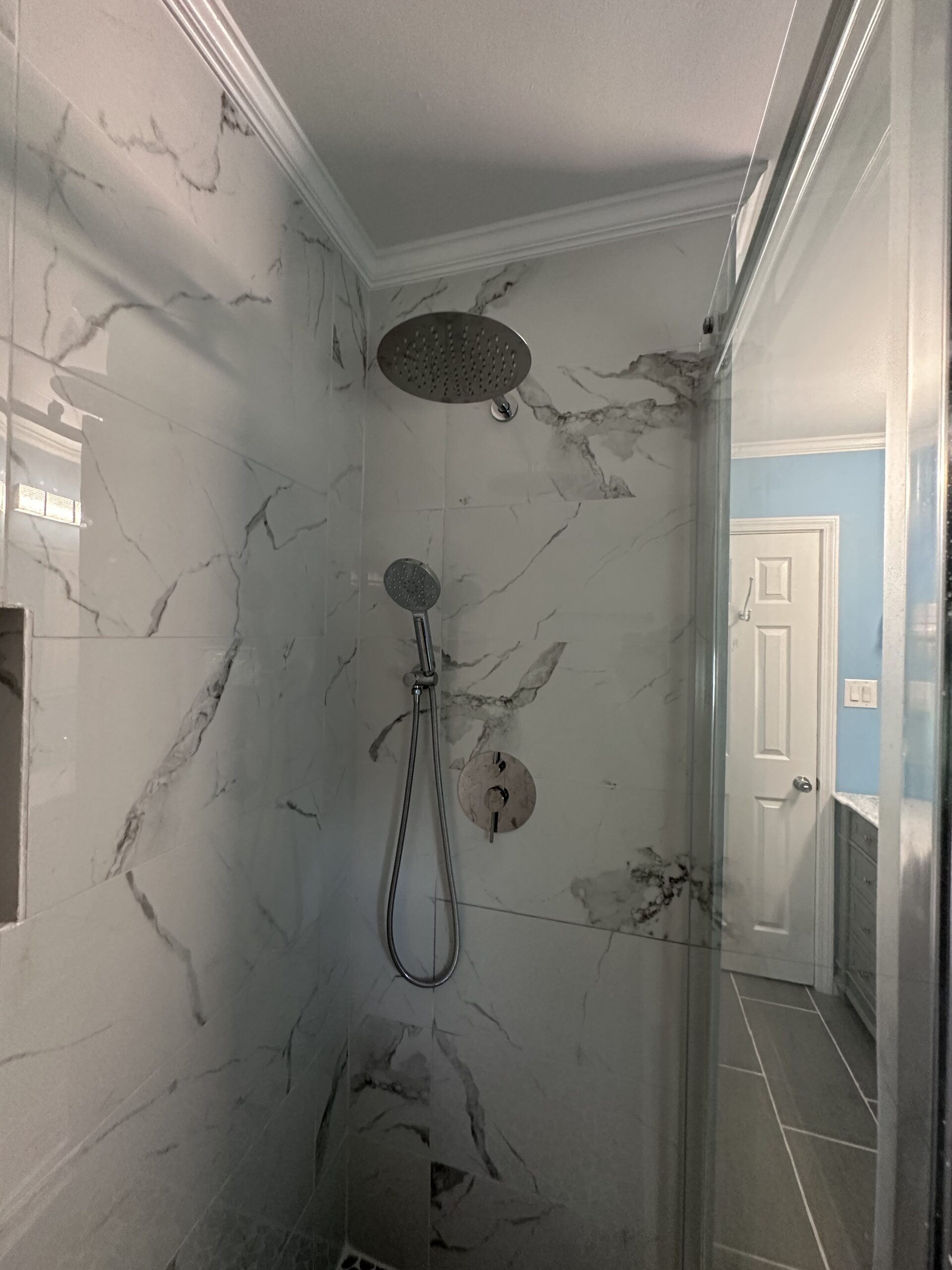 Bathroom Remodel Birmingham Alabama - Walk-In Shower Modern walk-in shower remodel with marble-patterned walls, rain showerhead, and brushed nickel finish hardware