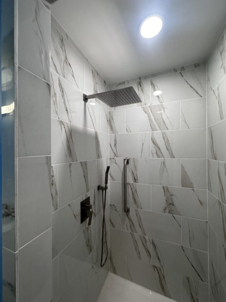 Luxury custom white marble tile walk-in shower installation with premium multi-head fixtures