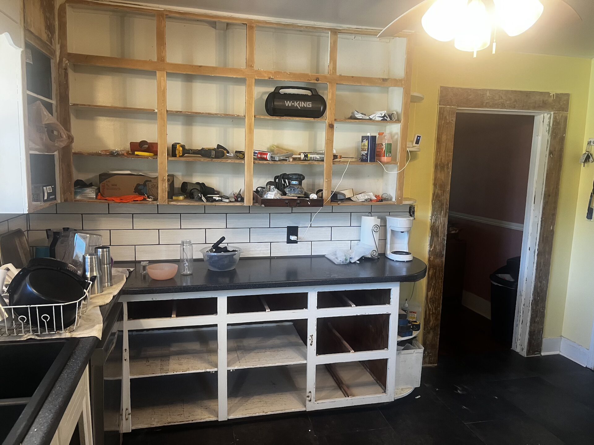 Before photo of a run-down kitchen remodel left unfinished by a previous contractor in Trussville AL, showcasing Bad Corian countertops and incomplete and wrong installed tile backsplash and vinyl floors before the Bystone renovation rescue.